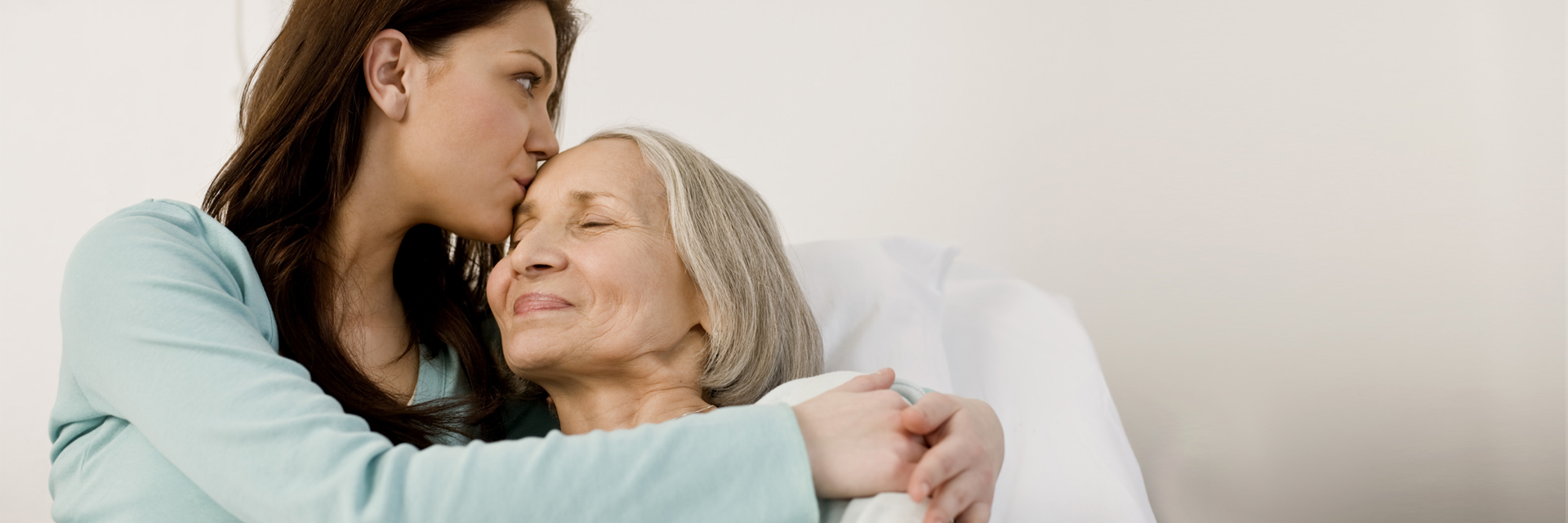 Daughter with woman in hospital bed