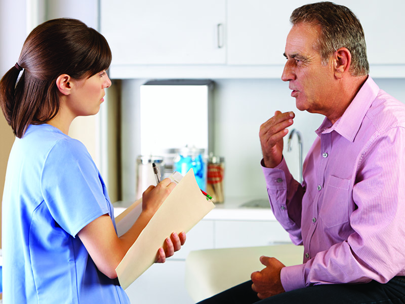 Male Patient on Exam Table Speaking with Nurse